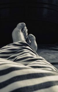 Low section of man relaxing on bed