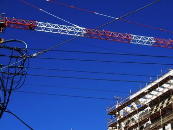 Low angle view of power lines against blue sky