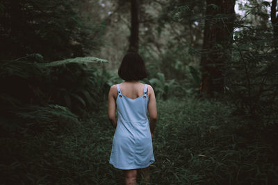 Rear view of woman standing on field