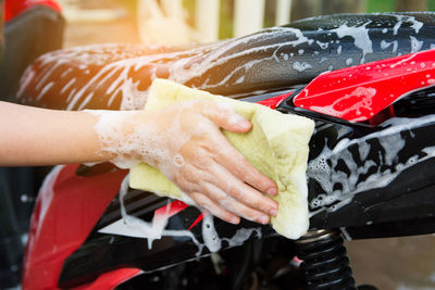 Close-up of person cleaning motorcycle