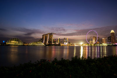 Singapore illuminated city against sky at night