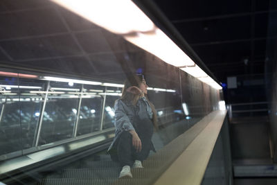 Rear view of man on escalator at railroad station