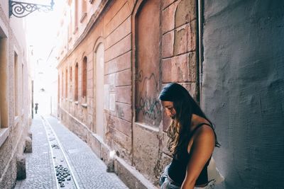 Side view of woman standing in front of building