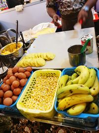 Midsection of man with fruits in container