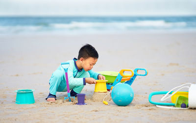 Boy playing with toy on beach