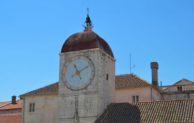 Low angle view of clock tower against clear blue sky