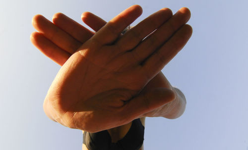 Low angle view of human hand against clear sky