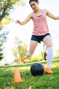 Woman playing soccer ball on field