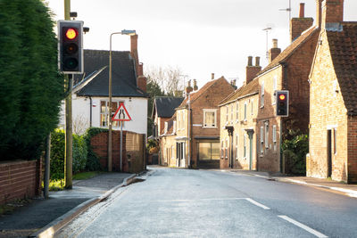 Street amidst houses and buildings against sky