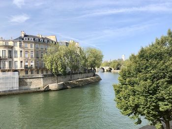 River amidst trees and buildings against sky