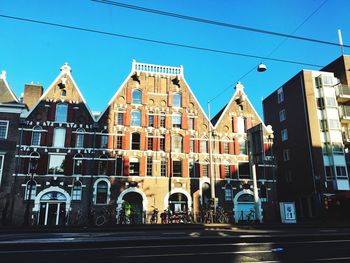 Street by buildings against blue sky