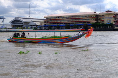 Boats in river with buildings in background