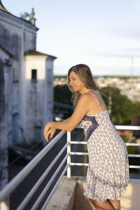 Young woman standing against building