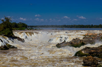 Scenic view of waterfall against sky