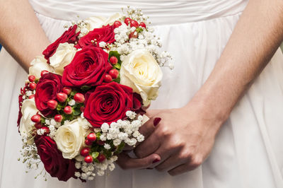 Midsection of bride holding bouquet