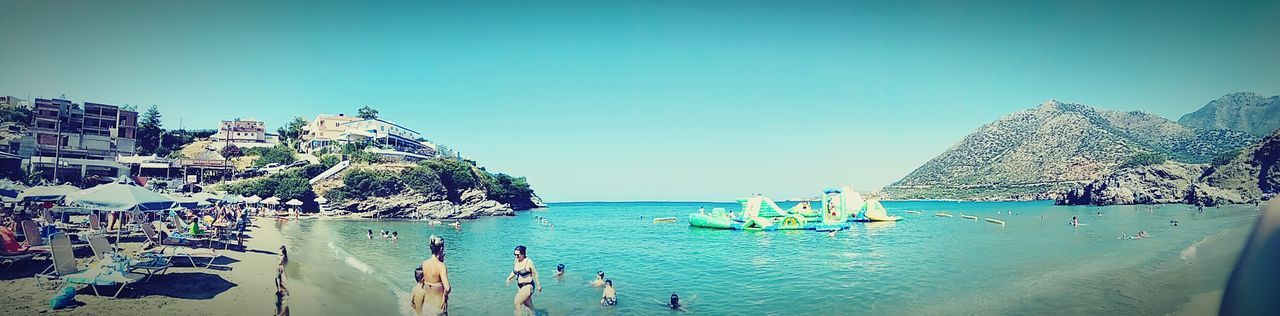 PANORAMIC VIEW OF PEOPLE ON BEACH AGAINST CLEAR SKY