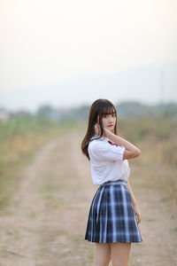 Woman standing on field against sky