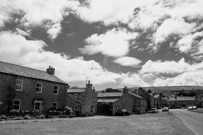 Houses by street in town against sky