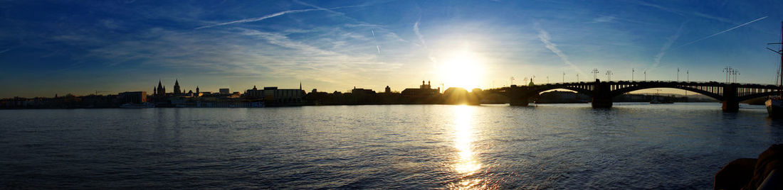 Bridge over river against sky during sunset