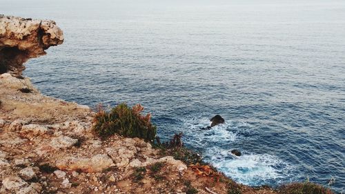 High angle view of rocks on sea against sky