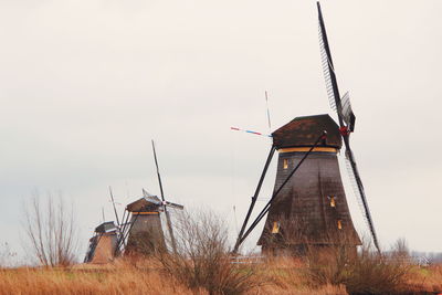 Traditional windmill on landscape against sky