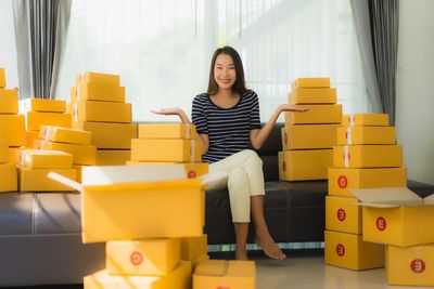 Portrait of young woman sitting on yellow indoors