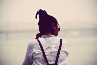 Rear view of man looking at sea against sky