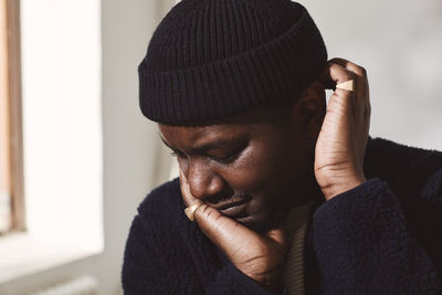 Mid adult man wearing knit hat against wall