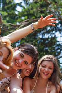 Portrait of happy friends against trees