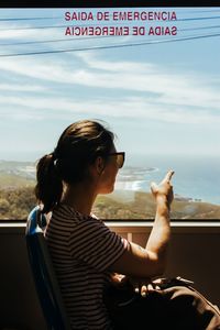 Man sitting in bus against sky