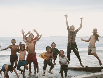 People enjoying on beach against sky