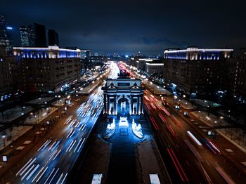 High angle view of illuminated city street amidst buildings at night