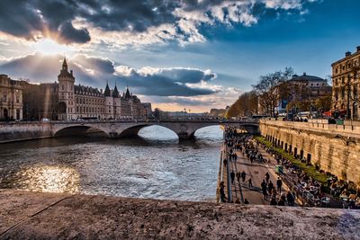 Arch bridge over river against buildings in city