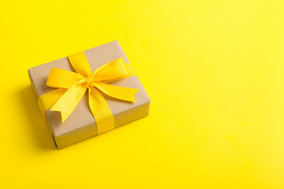 High angle view of gift on yellow background