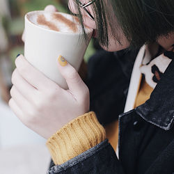 Close-up midsection of young woman drinking coffee