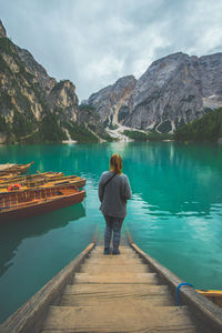 Rear view of woman looking at lake against mountain