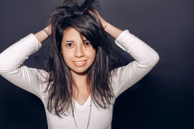 Portrait of beautiful young woman against black background