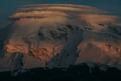 Scenic view of snowcapped mountains against sky during sunset