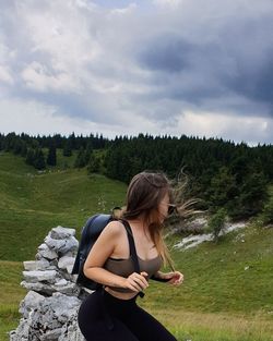 Full length of woman sitting on land against sky