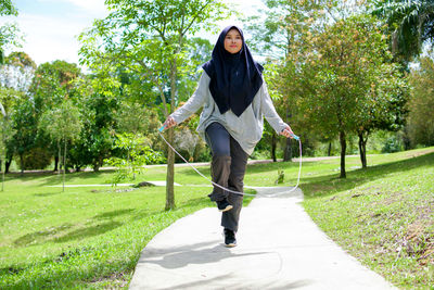 Portrait of young woman walking on road
