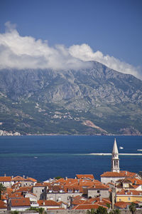 Aerial view of townscape by sea against sky