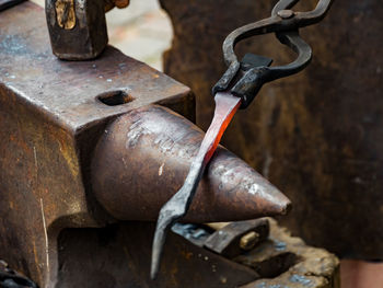 Close-up of pliers with metal on anvil