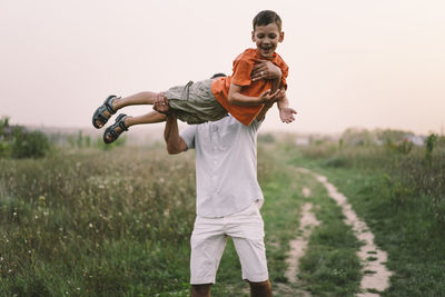 Happy fathers day. father with son are walking in the field.