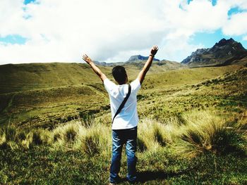 Rear view of man standing on field against sky