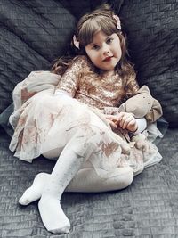 Portrait of cute girl sitting on sofa