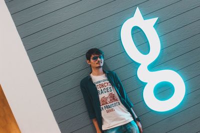 Man standing by text on wall