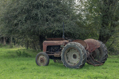 Tractor on field against trees