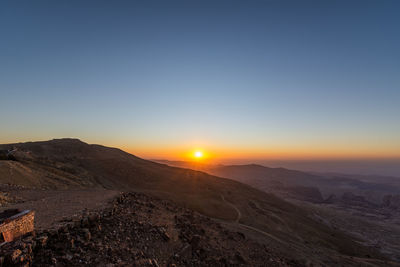 Scenic view of mountains against clear sky during sunset