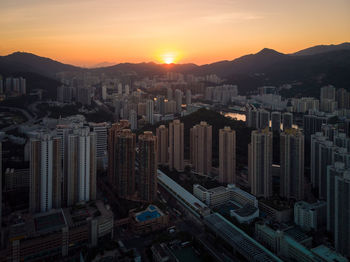 High angle view of modern buildings in city against sky during sunset