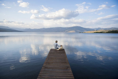 A woman and her dog enjoying an evening on the docks on hebgen lake.